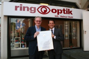 Bürgermeister Frank Keppeler gratuliert Helmut Stahl zu der Auszeichnung, die das ring- optik Fachgeschäft als 1a-Augenoptiker ausweist. 